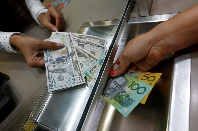 Australian dollar and U.S. dollar denominations are shown in a photo illustration at a currency exchange in Sydney, Australia, June 7, 2016. REUTERS/Jason Reed