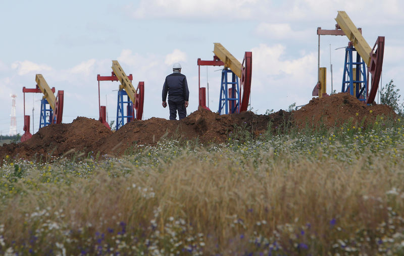 FILE PHOTO: A worker stands in front of pump jacks at the Ashalchinskoye oil field owned by Russia's oil producer Tatneft near Almetyevsk, in the Republic of Tatarstan, Russia July 27, 2017. REUTERS/Sergei Karpukhin/File Photo